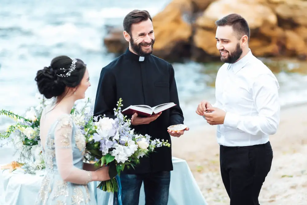 wedding-couple-near-ocean-with-priest