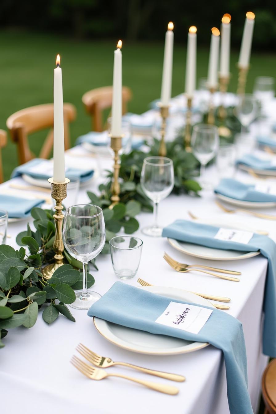 Blue-themed wedding table setting with candles and greenery