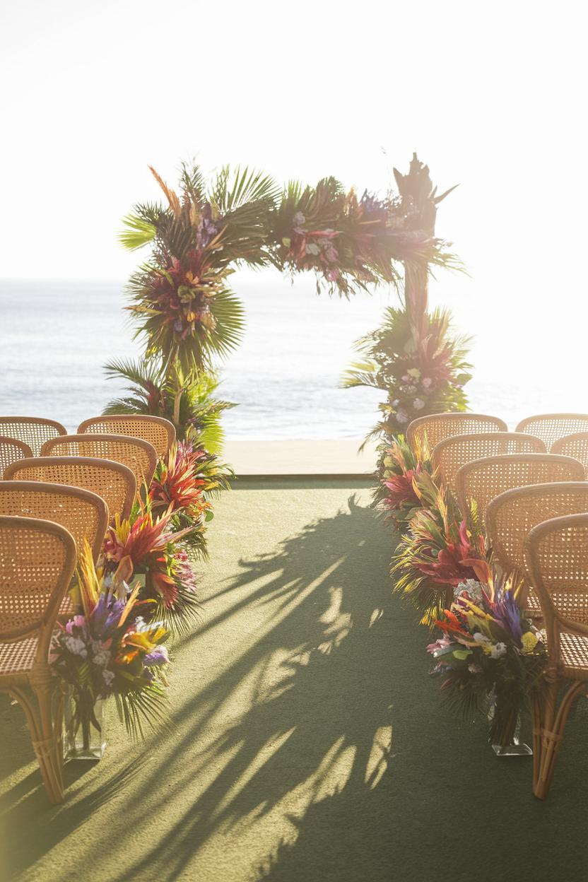 Vibrant floral arch and chairs set up by the ocean